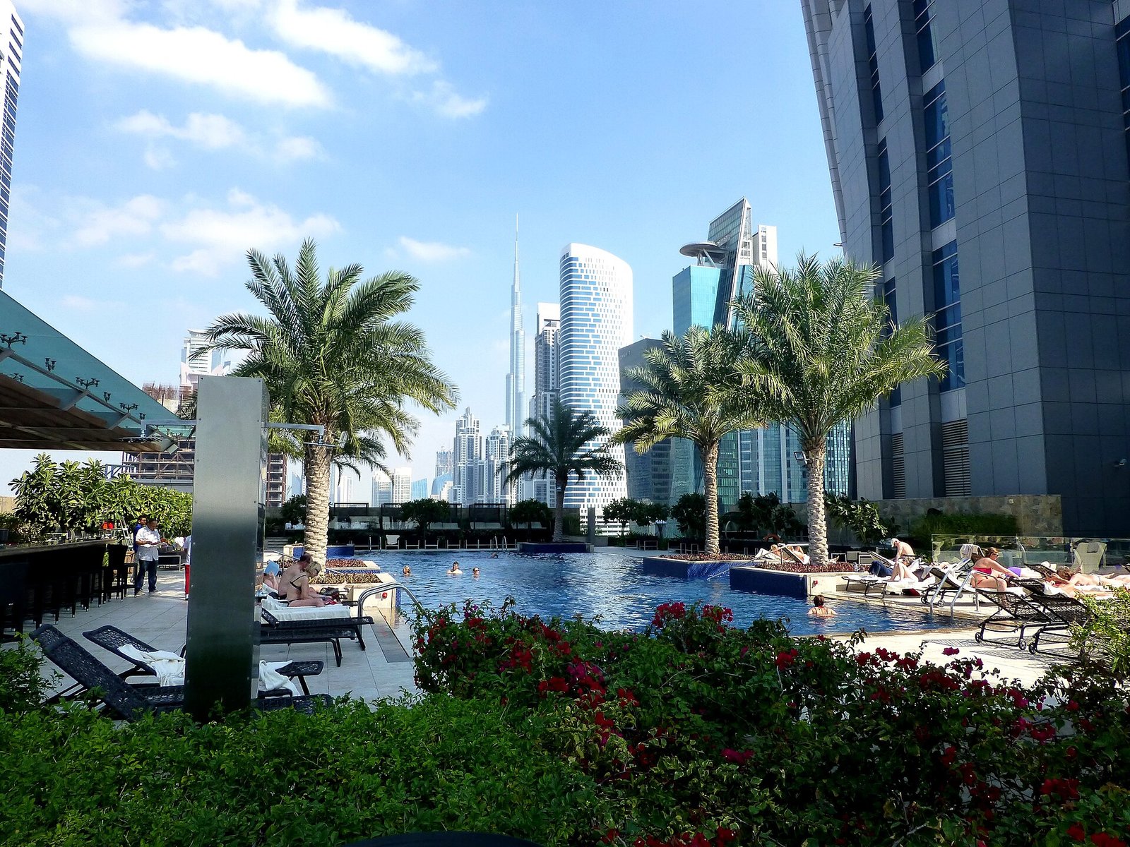 Swimming pool at a Dubai hotel resort with sun loungers and palm trees