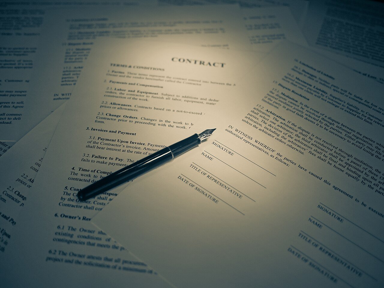 Fountain pen resting on a signed tenancy contract with a signature line, representing the documents needed for Ejari registration