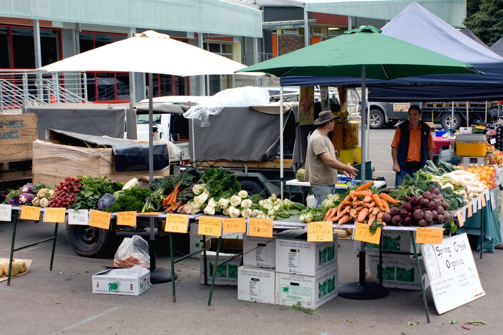 Organic vegetables and handmade goods on display at a farmers market stall
