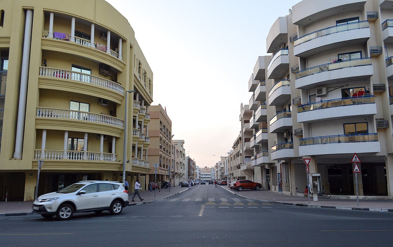 Residential neighbourhood in Bur Dubai with older apartment blocks, a common area for partition rooms and bed spaces