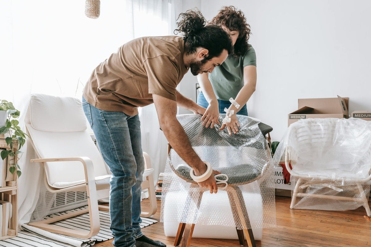 Movers and packers in Dubai wrapping furniture with protective packing materials